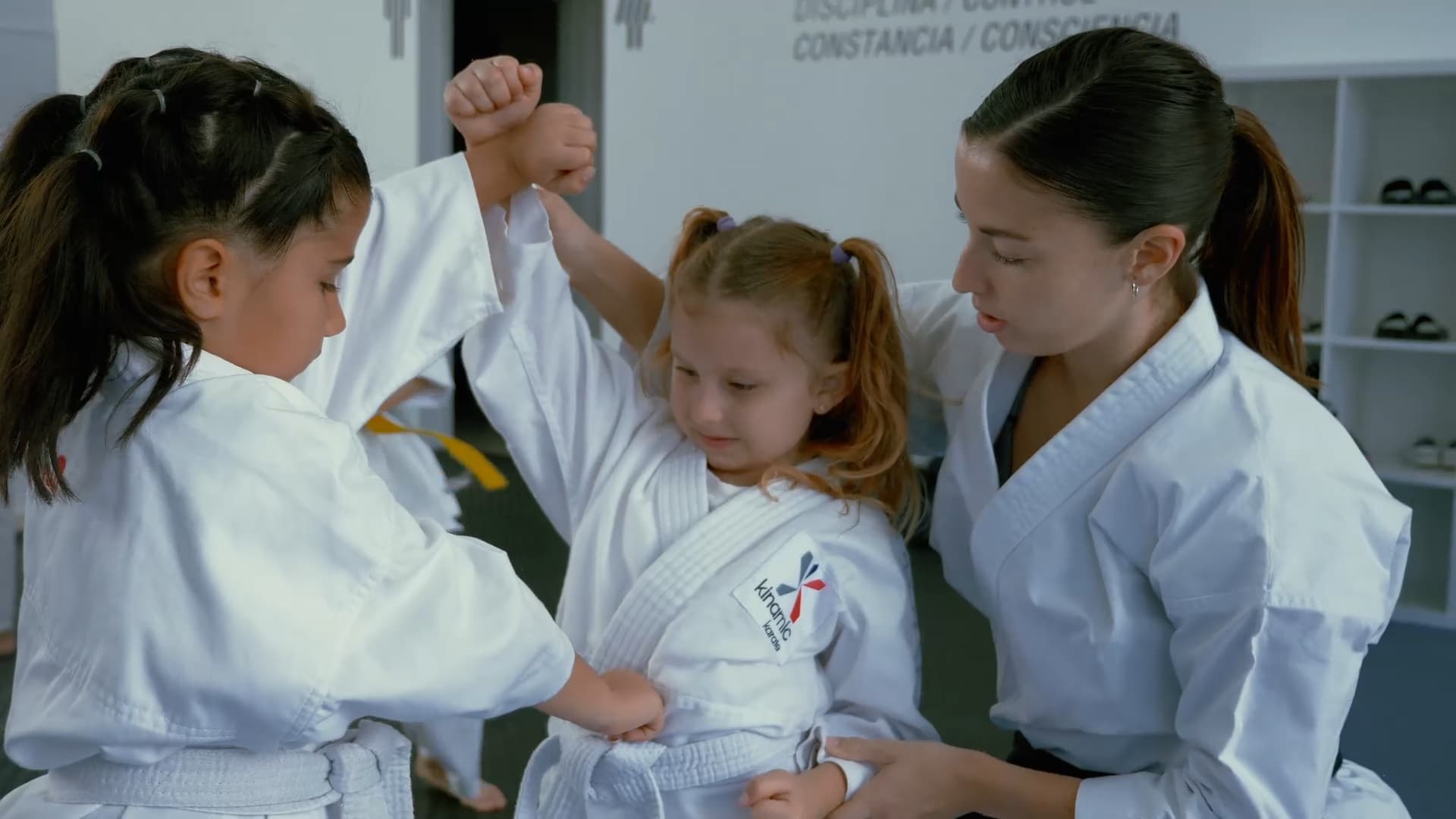 Instructora guiando a una alumna en el dojo Kinamic